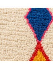 Détail de la surface bouclée en laine et des motifs berbères colorés du tapis