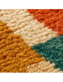 Gros plan sur les fibres épaisses, bouclées et irrégulières d’un tapis marocain en laine