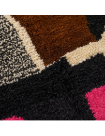 Détail de la texture moelleuse et irrégulière de la laine du tapis artisanal multicolore