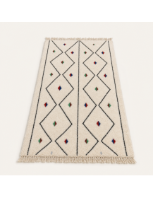Vue en perspective d’un tapis marocain en laine ivoire et noir avec losanges, chevrons et accents colorés