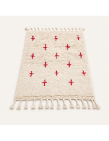 Vue en perspective d’un tapis marocain ivoire à motifs berbères rouges et poil épais