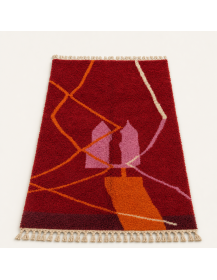 Vue en perspective d’un tapis Beni Ouarain en laine à poil épais et motif abstrait bordeaux