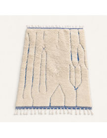 Vue en perspective d’un tapis berbère en laine ivoire écru à lignes bleu gris et texture shaggy