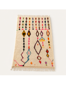 Vue en perspective du tapis Beni Ouarain en laine ivoire crème aux motifs géométriques multicolores