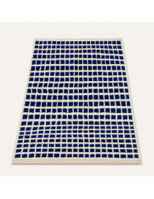 Vue en perspective d’un tapis artisanal marocain bleu foncé et écru au relief laineux