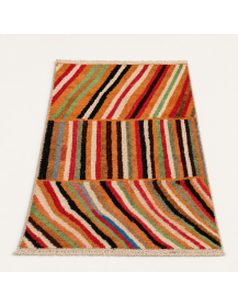 Vue en perspective d’un tapis Beni Ouarain en laine aux rayures terracotta, orange sable et noir