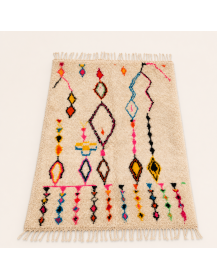 Vue en perspective d’un tapis berbère marocain en laine bouclée ivoire écru à motifs colorés