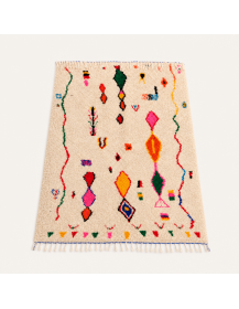 Vue en perspective d’un tapis berbère en laine écru ivoire aux motifs géométriques colorés