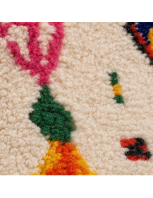 Détail du velours en laine et des motifs berbères colorés du tapis ivoire