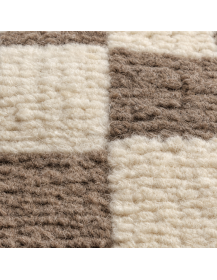 Détail de la texture mate de la laine et du subtil relief du damier ivoire et taupe
