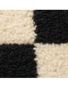 Détail de la texture moelleuse et des fibres épaisses en laine du tapis damier