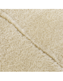 Détail de la texture douce de la laine ivoire et du relief géométrique gravé ton sur ton