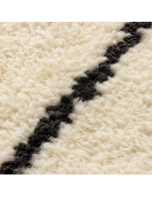 Détail de la texture duveteuse et irrégulière de la laine d’un tapis marocain artisanal