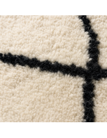 Détail de la texture laineuse mate et des motifs noirs irréguliers du tapis