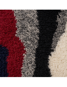 Détail de la texture laineuse du tapis avec fibres compactes, boucles courtes et mèches hirsutes