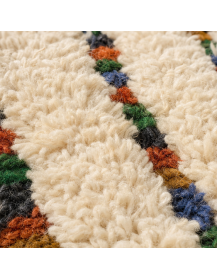 Détail de la laine dense et fibreuse du tapis ivoire, avec relief high-low et lignes géométriques irrégulières