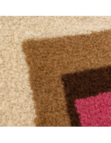Gros plan sur la texture dense, mate et légèrement bouclée de la laine du tapis marocain
