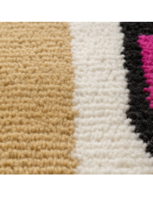 Détail de la texture dense et duveteuse de la laine sur un tapis artisanal marocain