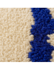 Détail de la texture moelleuse en laine et du motif bleu roi du tapis