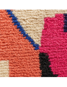 Détail des fibres de laine épaisses, bouclées et irrégulières du tapis rose poudré et écru