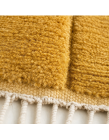 Détail de la texture en laine et du relief haut-bas du tapis marocain ocre doré