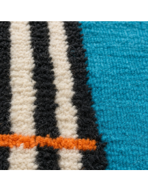 Gros plan sur la texture irrégulière et les fibres de laine du tapis Beni Ouarain turquoise