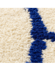 Détail de la texture laineuse et des motifs bleu profond du tapis artisanal marocain