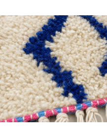Détail de la laine bouclée et des motifs géométriques bleu cobalt du tapis berbère