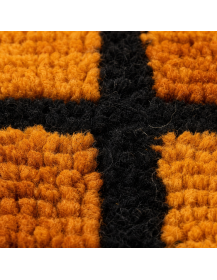 Détail des fibres de laine et du relief orange brûlé du tapis artisanal marocain