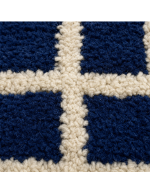 Détail des fibres de laine et du relief irrégulier du quadrillage bleu foncé et écru