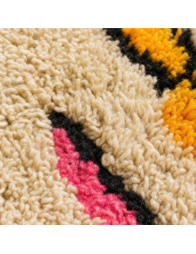 Détail de la texture shaggy en laine et des motifs géométriques multicolores du tapis berbère