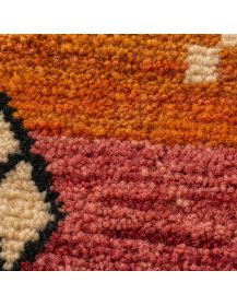 Détail de la texture mate et irrégulière de la laine du tapis marocain géométrique