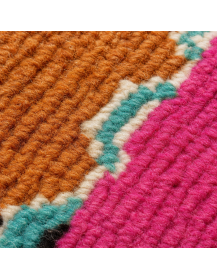 Détail de la texture laineuse mate, des stries horizontales et des motifs géométriques du tapis