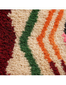 Détail de la texture laineuse irrégulière et des motifs géométriques colorés du tapis marocain