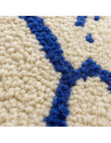 Détail de la texture moelleuse et irrégulière de la laine d’un tapis berbère bleu cobalt et écru