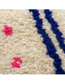 Gros plan sur la texture laineuse bouclée et les fibres irrégulières du tapis marocain