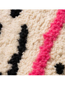 Détail de la texture laineuse touffetée et des motifs géométriques colorés du tapis