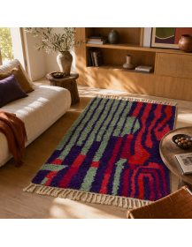 Tapis artisanal marocain vert sauge, violet et corail dans un intérieur contemporain