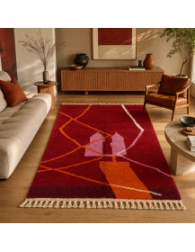 Tapis Beni Ouarain bordeaux et orange vif dans un salon contemporain chaleureux